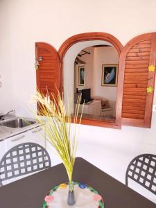 eine Küche mit einem Tisch mit einer Vase mit Gras in der Unterkunft Ingrid Romantic House in Stromboli
