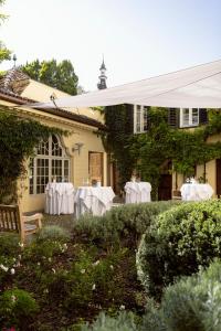 a table with white table cloths in the yard of a house at Parkhotel Laurin in Bolzano
