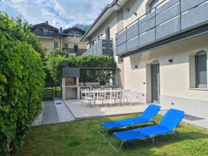 um quintal com duas cadeiras azuis e uma mesa em Suite vacanze Chabloz nel cuore della Valle d'Aosta em Nus