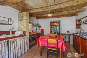 eine Küche mit einem Tisch und einem roten Tischtuch in der Unterkunft Casa dei Pini Country House in Osimo