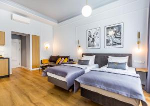 a hotel room with two beds and a couch at Bentis Luxury Apartments in Krakow