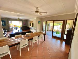 een woonkamer met een houten tafel en stoelen bij Selah Guest Cottages Self-catering Farmstay Accommodation in Nelspruit