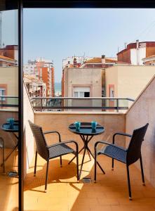 un patio con 2 sillas y una mesa en el balcón en Ático con terraza, vistas al mar y parking en playa de S Lorenzo, en Gijón