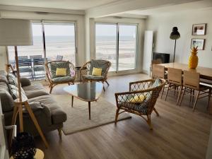 a living room with a couch and chairs and a table at Appart T4 lumineux avec terrasse vue mer in Le Touquet-Paris-Plage