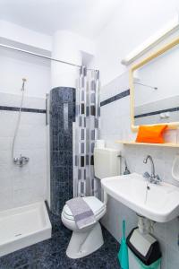 een badkamer met een wastafel, een toilet en een douche bij Sunshine Garden Apts in Malia