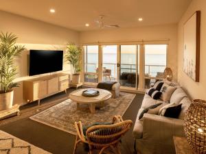 a living room with a couch and a tv at Sol Living Beach House in Brentwood