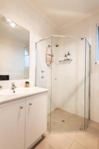 a bathroom with a shower and a sink at Sol Living Beach House in Brentwood