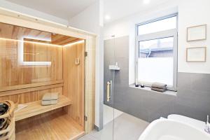 a bathroom with a shower and a toilet and a window at Op’n Diek in Fehmarn