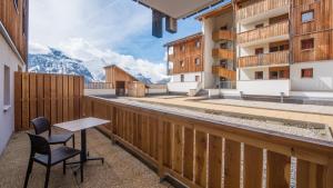 d'un balcon avec une table, des chaises et des montagnes. dans l'établissement Vacancéole - Les Etoiles d'Orion, à Orcières