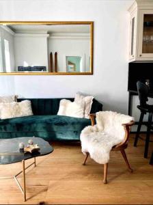 a living room with a green couch and a mirror at Brand-new, central apartment w/ VIEWS in Bad Gastein