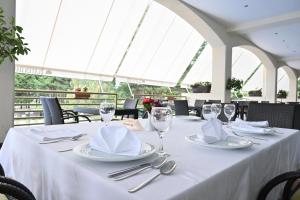 a table with silverware and napkins on a white table cloth at Hotel Bellevue - Metropol Lake Resort in Ohrid
