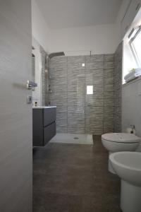 a bathroom with a shower and a toilet and a sink at Camera & Caffè - Accoglienza Salentina in Villaggio Resta
