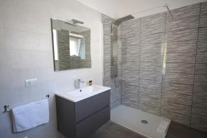 a bathroom with a sink and a glass shower at Camera & Caffè - Accoglienza Salentina in Villaggio Resta