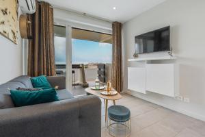 a living room with a couch and a tv and a table at Zen et Summer Zen coursive naturiste in Cap d'Agde