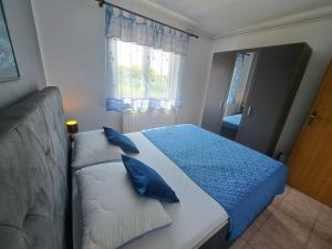 een slaapkamer met een bed met blauwe kussens erop bij Apartment Leo in Baška