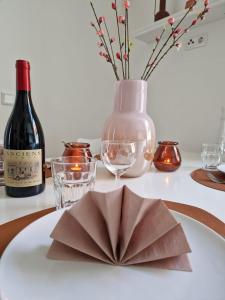 a plate with a napkin on a table with a bottle of wine at Gemütliche Familienwohnung in der Nähe des Nordparks und des Norparkcenters! in Bielefeld