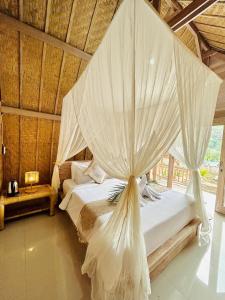 a bedroom with a bed with mosquito netting at Batur cottage in Kubupenlokan