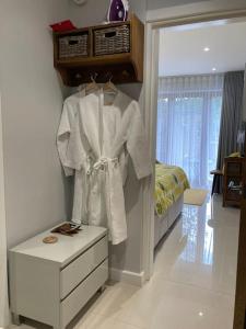 a bedroom with a white robe hanging on a wall at Malkin Wood Studio - 15 min walk to Holmfirth centre in Holmbridge