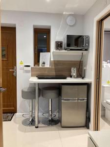 a kitchen with a counter with stools and a microwave at Malkin Wood Studio - 15 min walk to Holmfirth centre in Holmfirth