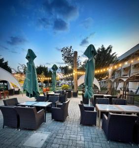 un patio avec tables, chaises et parasols dans l'établissement Voila Mamaia, à Mamaia