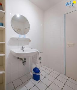 a white bathroom with a sink and a mirror at Ferienappartements Am Neuensiener See Ferienwohnung 2 in Sellin