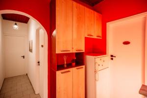 Una cocina con paredes rojas y gabinetes de madera. en Amaro apartment, en Laganas