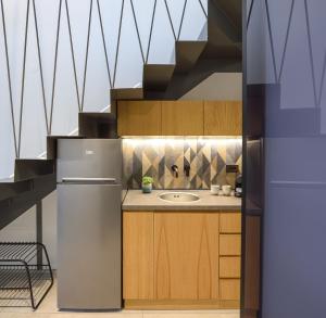 a kitchen with a refrigerator and a sink at Alea Suites -Adults Only and Kids 14 Plus in Asprovalta