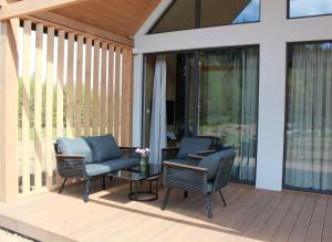 two chairs and a table on a porch with glass doors at Galena i Gnejs in Stronie Śląskie