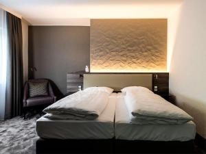 ラインフェルデン・エヒターディンゲンにあるHotel Am Parkのベッドルーム1室(壁に絵画が描かれたベッド1台付)