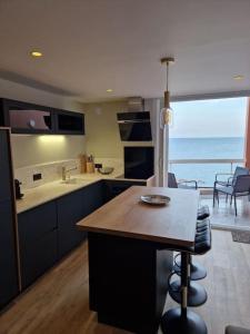 eine Küche mit Tisch und Blick auf das Meer in der Unterkunft CAP CORNICHE - Agréable Studio bord mer in Sète