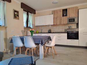 cocina con mesa azul y sillas blancas en Casa Vacanze Kristina, en Brissago Valtravaglia