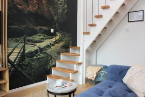 a living room with a blue couch and stairs at Galena i Gnejs in Stronie Śląskie