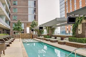 a pool with lounge chairs and a tv on a building at Downtown 1br w gym deck wd nr 6th St bars ATX-21 in Austin