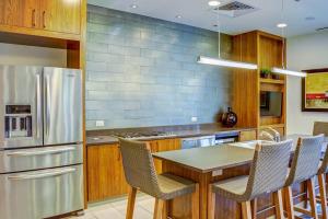 a kitchen with a stainless steel refrigerator and wooden cabinets at Downtown 1br w gym deck wd nr 6th St bars ATX-21 in Austin