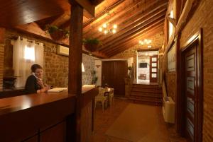 a woman sitting at a bar in a restaurant at Hotel Campos de Castilla in Soria