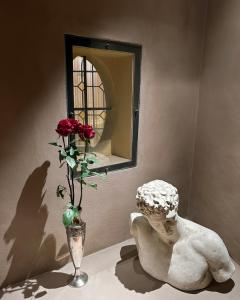 una statua di una donna con un vaso con una rosa di Castellata La Suite a Bologna