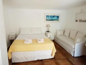 Habitación blanca con cama y sofá en Nostalgia Guesthouse, en Skoutari