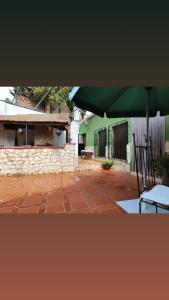 eine Terrasse mit einem grünen Sonnenschirm, einem Tisch und einem Stuhl in der Unterkunft Cueva Rural El Sendero in Pegalajar
