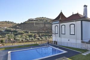 a house with a swimming pool next to a building at Casa de Cambres in Lamego
