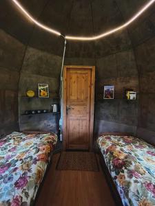 um quarto com duas camas e uma porta numa tenda em Mežagaiļu idiļļa em Rezekne