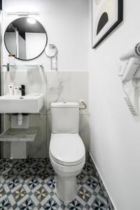 La salle de bains est pourvue de toilettes blanches et d'un lavabo. dans l'établissement Apartments WS Louvre - Saint-Roch, à Paris