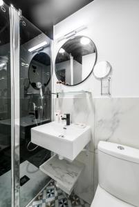 La salle de bains est pourvue d'un lavabo, de toilettes et d'un miroir. dans l'établissement Apartments WS Louvre - Saint-Roch, à Paris