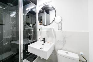 La salle de bains blanche est pourvue d'un lavabo et d'un miroir. dans l'établissement Apartments WS Louvre - Saint-Roch, à Paris