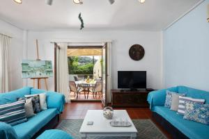 a living room with a blue couch and a table at Villa Lianolia in Perítheia
