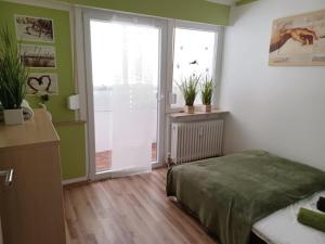 um quarto com uma cama e uma porta de vidro deslizante em H&A Apartment Baden Baden em Baden-Baden