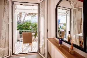 Una habitación con espejos y un balcón con una mesa. en Amaro apartment, en Laganas