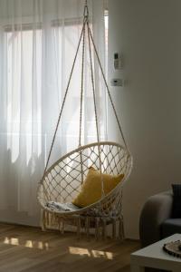 a hanging chair with a yellow pillow in a living room at Apartment Pemper - Self check in and check out in Otočac