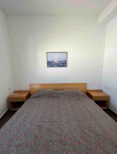 a bedroom with a bed with two nightstands and a picture at Finca la Pampa in Arafo