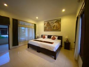 - une chambre avec un grand lit et une fenêtre dans l'établissement Brata Inn Ubud, à Ubud