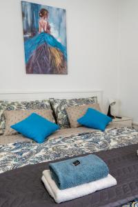 a bedroom with a bed with blue pillows and a painting at Apartment Pemper - Self check in and check out in Otočac